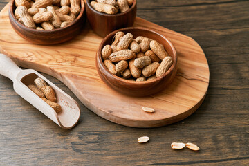 Image of wooden spoons with peanuts on a wooden table