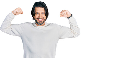 Middle age caucasian man wearing casual clothes showing arms muscles smiling proud. fitness concept.