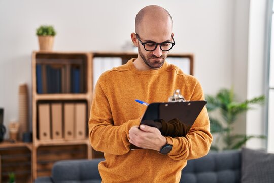 Young man business worker writing on clipboard at office