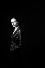 woman with closed eyes in leather coat and, black background