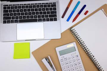 Office stationary note book, pen and laptop , working equipment. office table desk workspace with blank notebook,  calculator