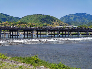 晴れた日の観光シーズンの嵐山の渡月橋