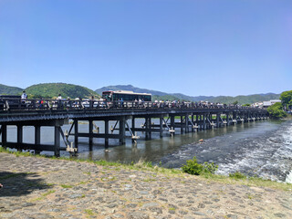 晴れた日の観光シーズンの嵐山の渡月橋