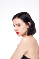 brunette woman with red lips in black top, white studio background