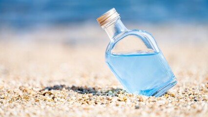 【ビーチ】海の白い砂浜の上のガラスボトル

