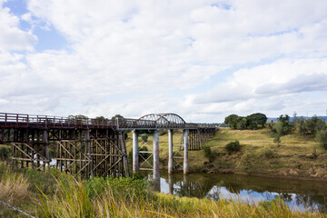 Old wooden bridge with many large trestles crossing Munna Creek at Miva in the South Burnett region of Queensland Australia