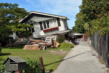 Earthquake - Lower storey of house collapses.