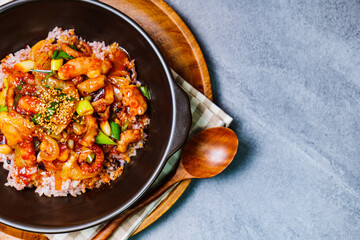 Nakjideopbap, Korean style spicy stir-fried octopus over rice : This dish is made by stir-frying sliced onion and carrots along with sauce over high heat in an oiled pan. Bite-sized pieces of octopus 