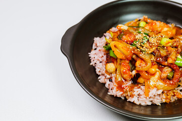 Nakjideopbap, Korean style spicy stir-fried octopus over rice : This dish is made by stir-frying sliced onion and carrots along with sauce over high heat in an oiled pan. Bite-sized pieces of octopus 