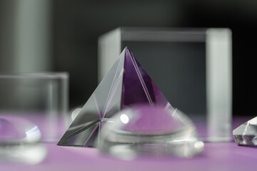 Crystal prism refracting light, magic crystals and pyramid, sphere and cube on purple background....