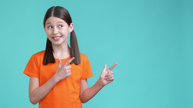 Schoolchild demonstrate empty space offer isolated cyan color background