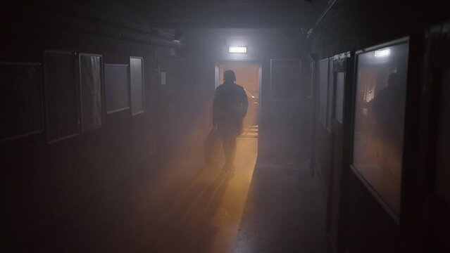 Panning A Man As He Walks Through A Dark Hallway Carrying A Guitar Case With Dramatic Back-Lighting - Erfurt, Germany