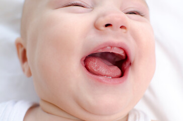 Smiling baby mouth close-up. Infant primary teeth. Children healthcare and soothing concept