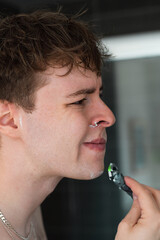 Closeup face of young man shaving in the bathroom