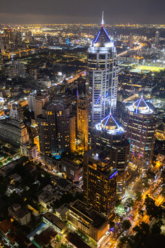 Aerial view of Ploenchit junction with cars traffic skyscraper buildings. Bangkok City in downtown at night, Thailand