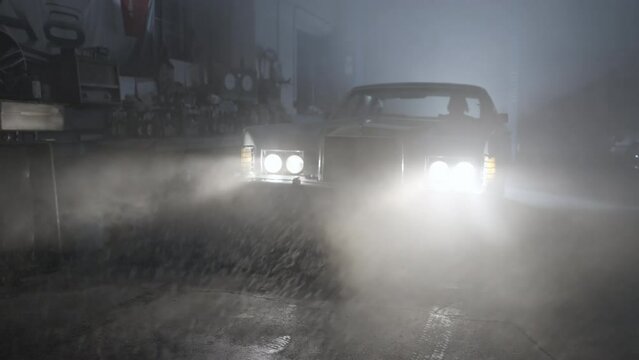 Panning Through Rain And Smoke Of A Car Parked In A Garage With Headlights On - Erfurt, Germany