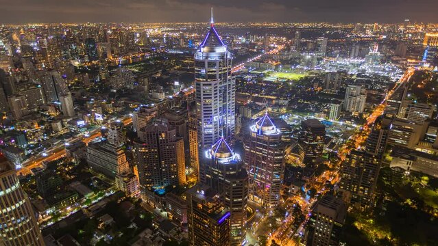 Aerial view of Ploenchit junction with cars traffic skyscraper buildings. Bangkok City in downtown at night, Thailand