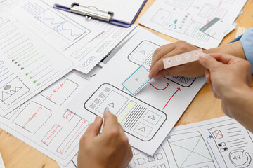 Graphic designers work together with UX UI designer planning application template layout framework for mobile phone computer mobile
