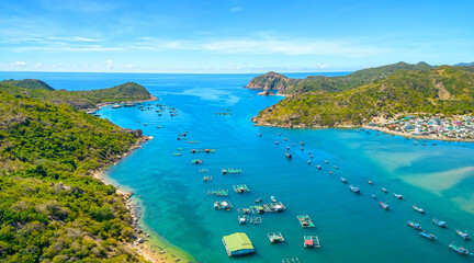 Vinh Hy Bay viewed from above at noon in summer with hundreds of fishing boats moored and fishing villages below. This is a beautiful bay to visit in Ninh Thuan, Vietnam