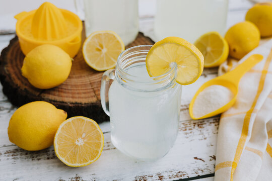 Jar glass of lemonade drink with yellow lemons or lime on a white background in Latin America