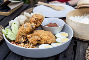 Nasi lemak with fried chicken, anchovis, eggs, groundnuts and sambal is popular Malaysia delicacy, served with rice cooked in coconut milk