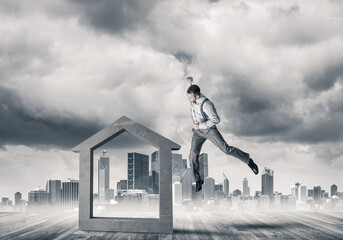 Manager man crashing stone home as symbol for real estate insurance