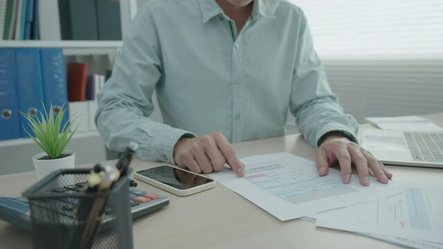 man is using a phone scan to verify the details according to the documents.man checks documents and scans to pay the invoice.new normal. Concept Scan QR code for paying online...