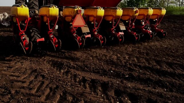 A modern tractor with sows a field. . A farmer on a tractor plows dusty arid soil and sows cereal grains. Agribusiness in the spring. Agricultural work in the fields, agribusiness. Selective focusing