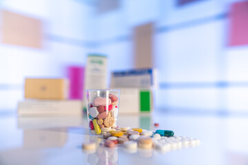 Colorful tablets with capsules and pills on mirror surface and blurred background