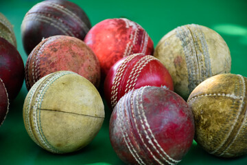 Closeup old and used leather cricket balls on green floor, soft and selective focus. concept for cricket lover around the world.