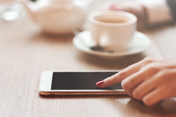 Business woman hands using smart phone and cup of coffee.