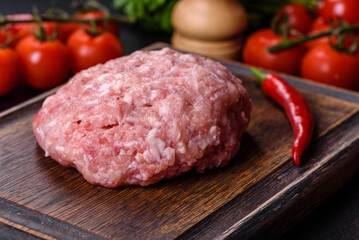 Ground meat with ingredients for cooking on black background