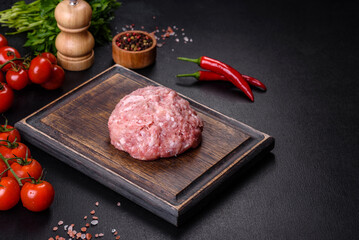 Ground meat with ingredients for cooking on black background