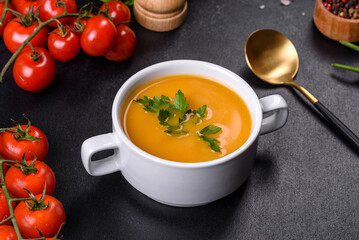 Delicious fresh pumpkin puree soup decorated with parsley in a white plate