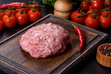 Ground meat with ingredients for cooking on black background