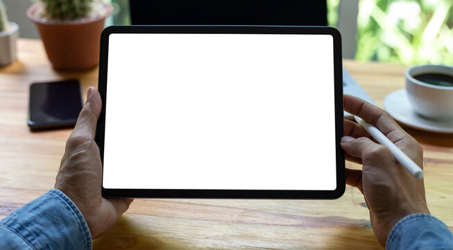 mock up empty screen tablet, businessman working on his tablet with blank space screen for advertising text on wood desk in office