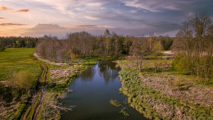Polish landscape with a small river in the background at sunset.