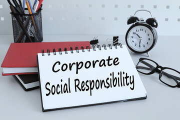 Corporate Social Responsibility Concept. open notepad with text on work gray table