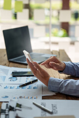 Asian Businessman working to analyze technical price graph and indicator with business team talking by cell phone. account or saving money or insurance concept.