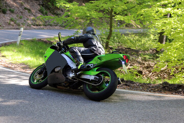 Sportlicher Motorradfahrer bei einem Ausflug ins Grüne 