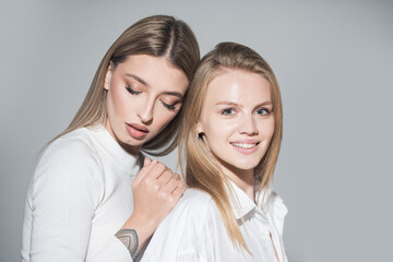 Portrait of two cheerful young women. Two beautiful young women with perfect skin in the studio. Lesbians lgbt couple.