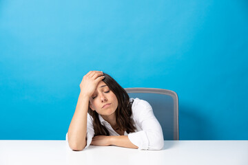 Despaired young hispanic woman isolated on blue background. Stress, anxiety and depression concept.