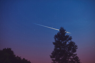 Stars, meteor trail on evening sky.