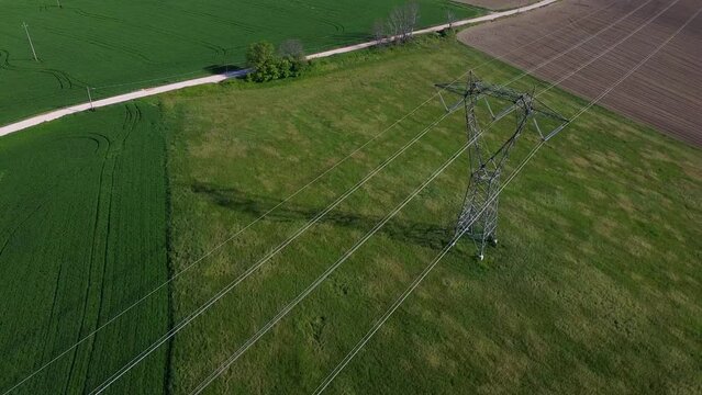 drone fly over high voltage pylons and cables for the electricity transport industry in a sunny day