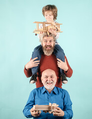Men generation: grandfather father and grandson are hugging looking at camera and smiling. Family adventure, imagination and innovation inspiration concept.