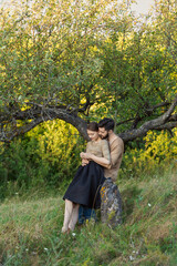 young couple hugging near a tree