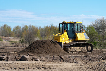 The bulldozer level the ground.  Caterpillar tractor.