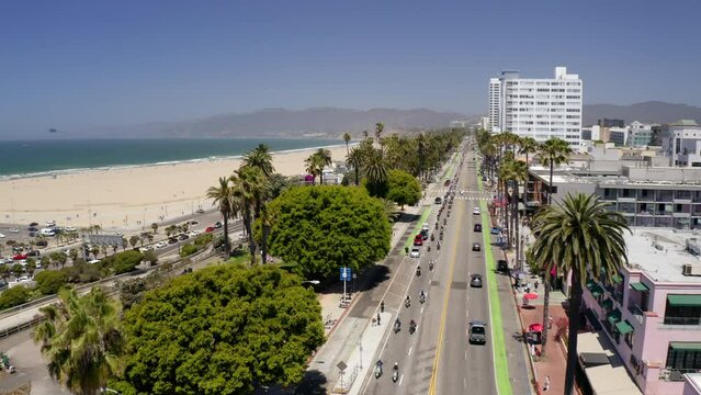 Aerial Forward Shot Of People Riding Motorcycles At Event On Road By Beach In City - Santa Monica, California