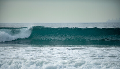 Fototapeta premium Panorama of ocean waves on a tropical sea with deep blue wawes. Calm sea water, ocean background. Panoramic landscape. Sea foam.