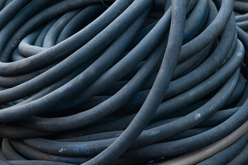 Pile of twisted, high pressure rubber hoses, close-up.